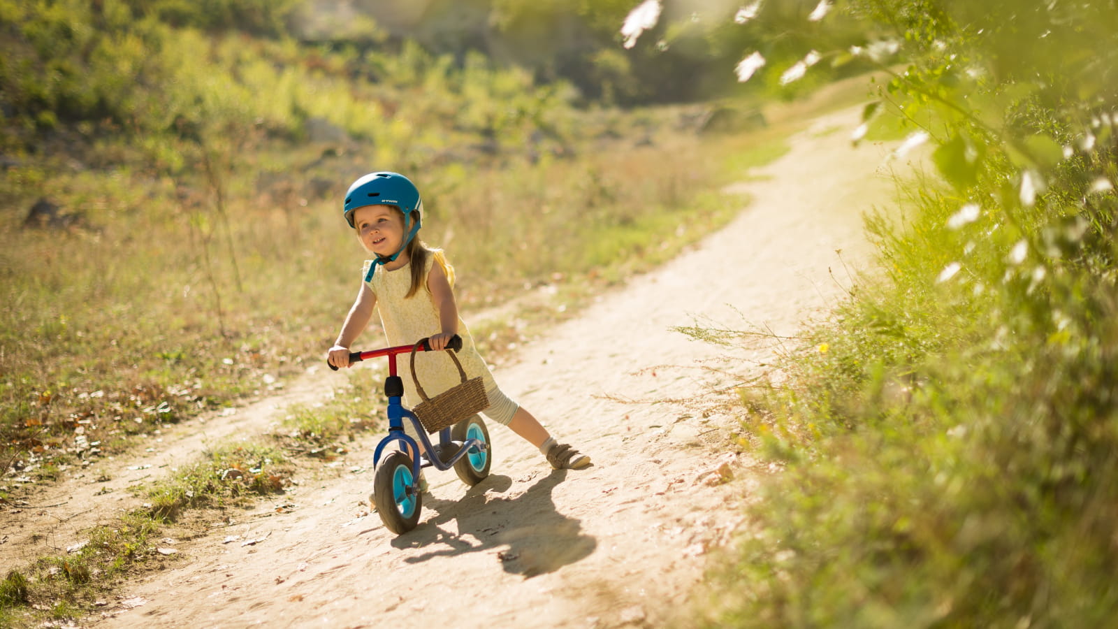 Petite fille à vélo sur un sentier de prairie